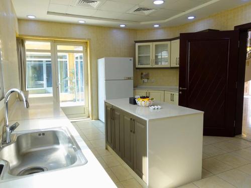 a kitchen with a sink and a refrigerator at Private Room Villa Dubai in Dubai
