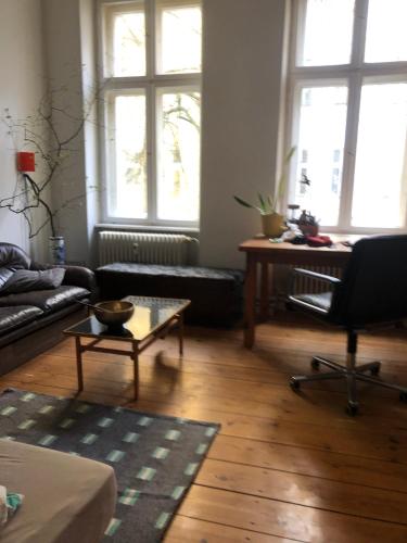 - un salon avec un canapé, une table et des fenêtres dans l'établissement Imagination in the Heart of the city, à Berlin
