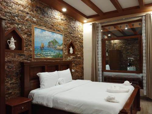 a bedroom with a bed and a painting on the wall at Durrat Nizwa Inn in Nizwa