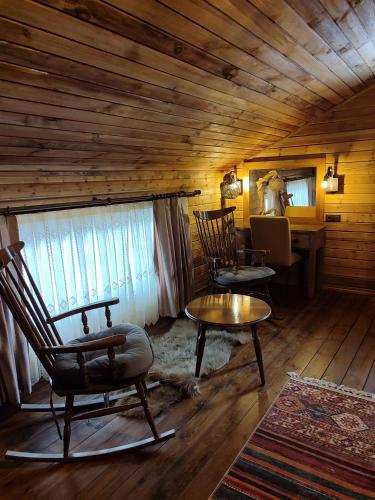 a room with rocking chairs and a table and a desk at Karinna Orman Evleri & Non Alcohol in Uludag