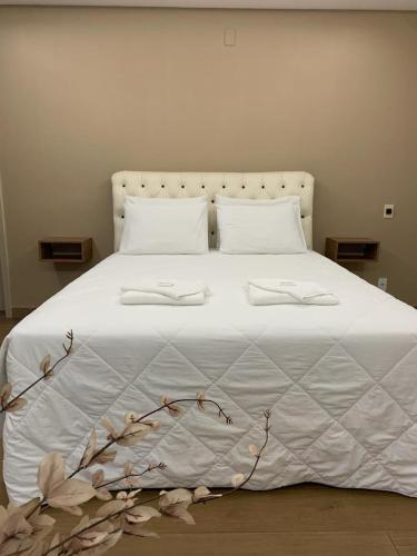 Una cama blanca con dos almohadas blancas. en Gran Lord Hotel en Pará de Minas