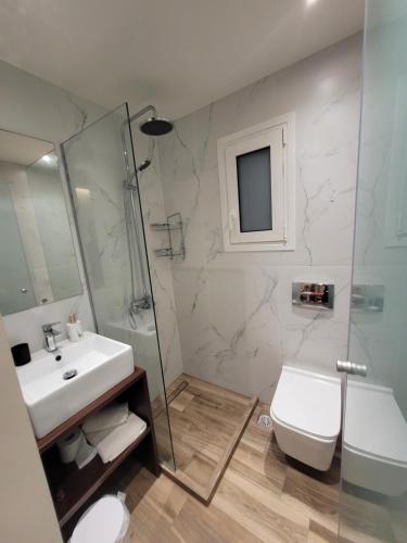 y baño con lavabo, aseo y ducha. en Vasiliki Apartments, en Plataniás