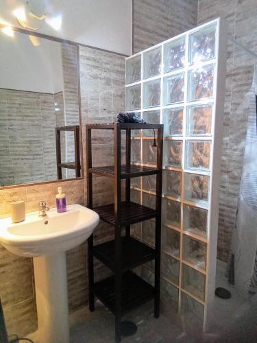 a bathroom with a sink and a toilet and a shelf at Apartamento Caños de Meca in Los Caños de Meca