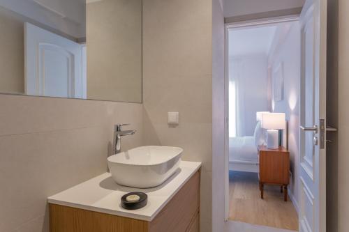 a white bathroom with a sink and a mirror at BeGuest Retiro da Guia in Cascais