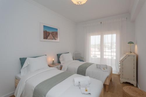 two beds in a room with white walls at BeGuest Retiro da Guia in Cascais