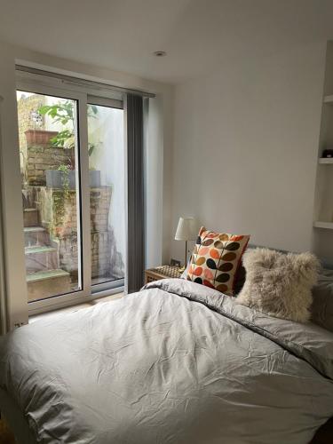 a bedroom with a bed and a large window at Stylish Garden Flat in London