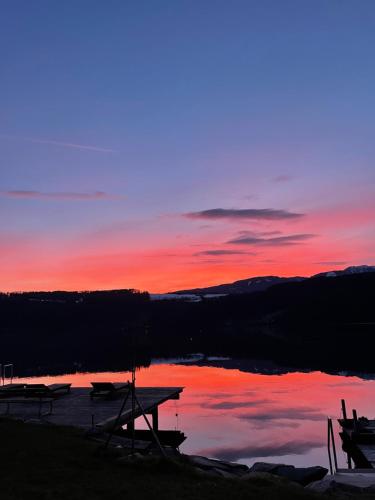 a sunset over a lake with two boats on it at Ferienwohnungen Seerose in Dellach direkt am Millstätter See in Millstatt