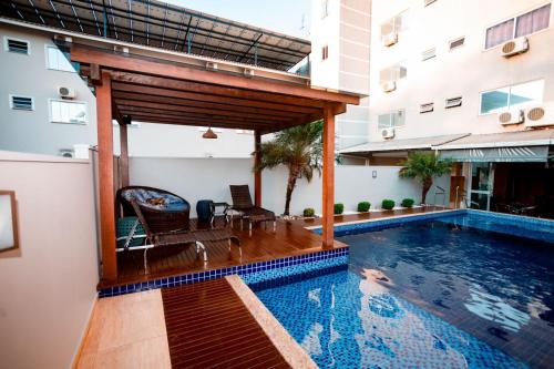 uma piscina com uma pérgula ao lado de um edifício em Nayru Hotel em Toledo