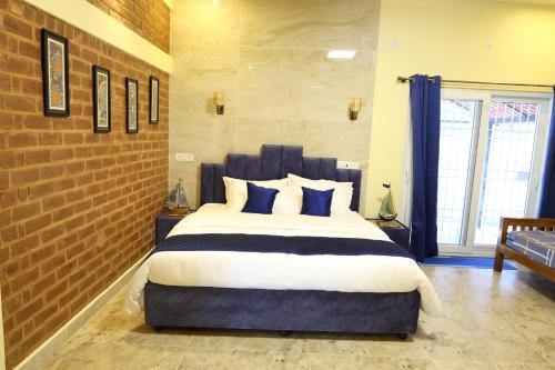 a bedroom with a large bed with blue pillows at Athulya Resort -Leisure and Luxury cottages from EMBEHolidays in Kottaikadu