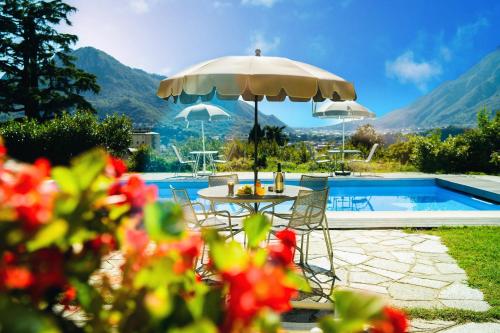 a table with an umbrella next to a swimming pool at Montebello Lake in Lecco