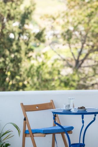 a blue table and a chair on a porch at Galini me thea in Chrissi Akti