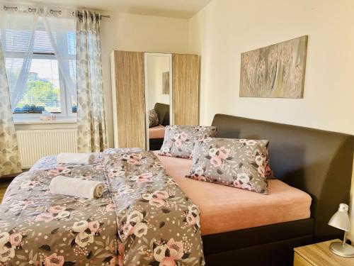 a bedroom with a bed with floral sheets and pillows at Villa Emilia in Nový Šaldorf