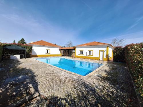 a swimming pool in front of a house at Quinta São José in Coruche