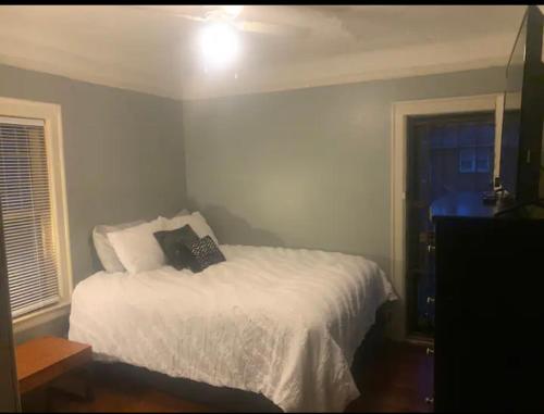 a bedroom with a white bed and a window at Marygrove Manor in Detroit