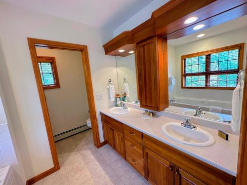 baño con 2 lavabos y espejo grande en SH1 Beautiful StoneHill Townhouse in Bretton Woods en Bretton Woods