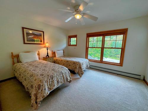 a bedroom with two beds and a ceiling fan at SH1 Beautiful StoneHill Townhouse in Bretton Woods in Bretton Woods