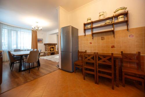 una cucina e una sala da pranzo con tavolo e frigorifero di Alatau Гостевой Дом a Shchuchinsk