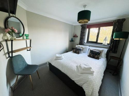 a small bedroom with a bed and a chair at Urban Oasis in Billericay