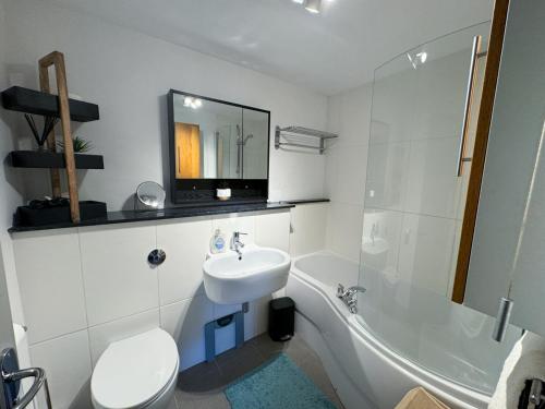 a bathroom with a sink and a toilet and a tub at Urban Oasis in Billericay