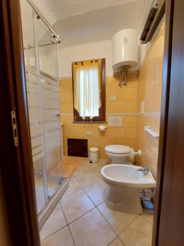 a bathroom with a toilet and a shower and a sink at Casa L' Antico Ulivo in Iglesias