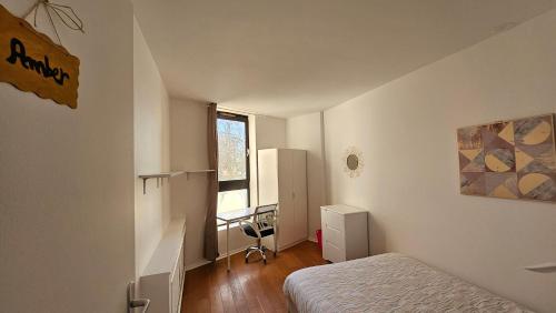 a bedroom with a bed and a desk and a window at The Lake House rooms - 20 min to Paris by metro in Créteil