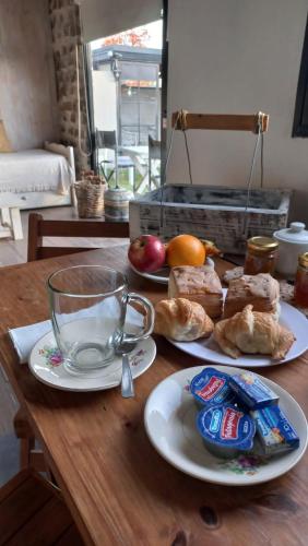 グアレグアイチュにあるPiedra Mora Loftの食べ物の皿が2枚置かれた木製のテーブル