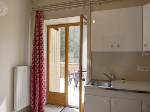 eine Küche mit einem Waschbecken und eine Tür zu einer Terrasse in der Unterkunft Gîte Cherier, 3 pièces, 4 personnes - FR-1-496-288 in Chérier