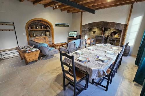 une salle à manger avec une table et une cheminée dans l'établissement L'Oustal dé l'Adrienne é Jean , Gite de campagne au pied des montagnes, à Tournemire