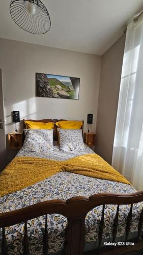 - une chambre avec un lit doté de couvertures et d'oreillers jaunes dans l'établissement L'Oustal dé l'Adrienne é Jean , Gite de campagne au pied des montagnes, à Tournemire