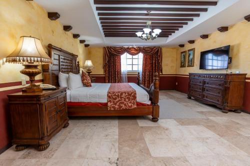 een slaapkamer met een bed, een bureau en een televisie bij Hotel Ocean View in Campeche