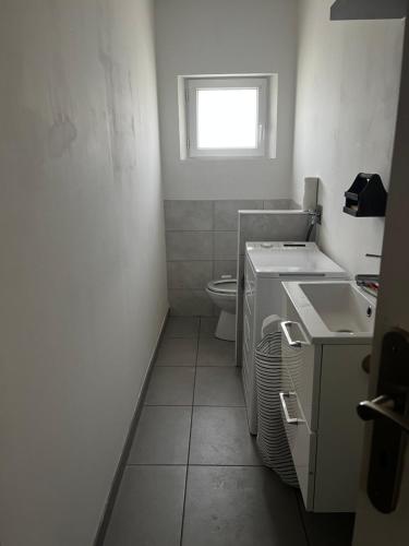 La petite salle de bains est pourvue de toilettes et d'un lavabo. dans l'établissement Appartement à Mailly-le-camp, à Mailly-le-Camp