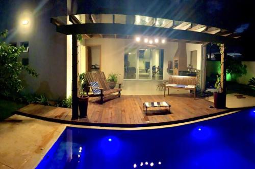 ein Wohnzimmer mit einem Pool in der Nacht in der Unterkunft Casa de Campo RSC XIII - Represa Jurumirim - SP in Paranapanema