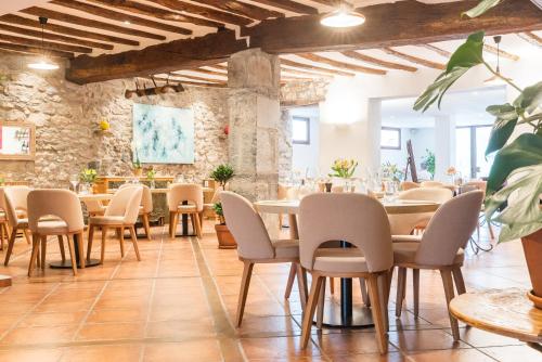 a restaurant with tables and chairs in a stone wall at Hotel La Maison Oppoca in Aïnhoa