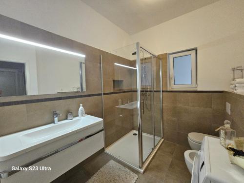 a bathroom with a shower and a sink and a toilet at Apartmani Dianna in Kaštela