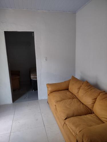 a living room with a brown couch in the corner at Kit Parque Amazonia in Goiânia