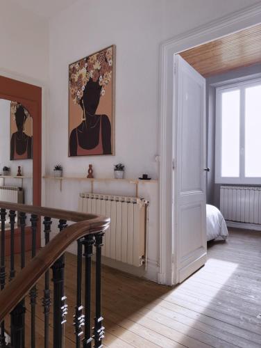 Habitación blanca con escalera y dormitorio en Élégance et Charme au Cœur des Vignes - Piscine et Décoration Artisanale en Le Pian-sur-Garonne