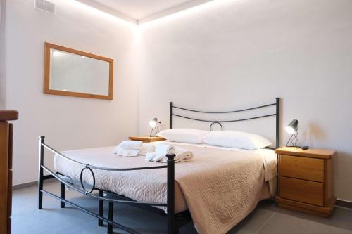 1 dormitorio con 1 cama con sábanas blancas y espejo en Case VR Holiday ResiRenza en Verona
