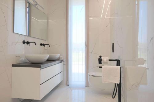 Baño blanco con lavabo y espejo en Case VR Holiday ResiRenza en Verona