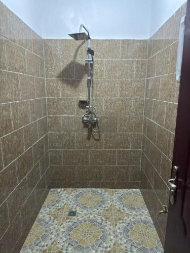 a bathroom with a shower with a tile floor at Villa à Malicounda 3 chambres, piscine, calme et confort à 10 min de Saly in Malikounda