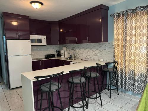 Catanoにある3BR, 1BA Spacious Property in Cataño, Near Bacardíのバースツール付きの島のあるキッチン