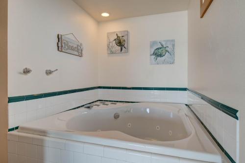 a bath tub in a bathroom with three pictures on the wall at Ester Lee Motel in Lincoln City