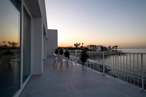 balcone con sedie e vista sull'oceano di Calammare Apartments - Luxury Apartments with Beach and Gym - Molfetta a Molfetta