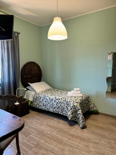 a bedroom with a bed and a table and a lamp at LA TERRAZZA SU ROMA in Zagarolo