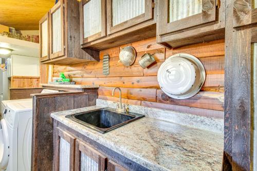 a kitchen with a sink and wooden walls at Expansive Mountain Home Rental with Yard and Fire Pit! in Mountain Home