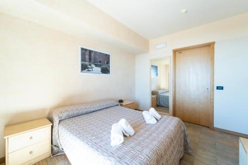 una camera da letto con un letto con scarpe bianche di Rifugio Sapienza a Nicolosi