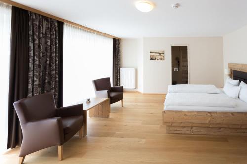 a bedroom with two beds and a desk and chairs at Hotel Dirsch Wellness & Spa Resort in Emsing