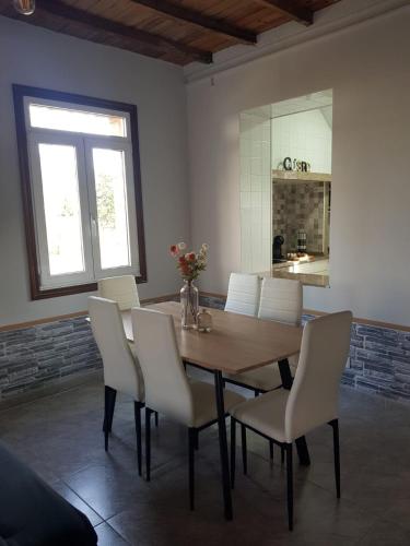 a dining room with a wooden table and white chairs at Casa La Porriñesa in Porriño