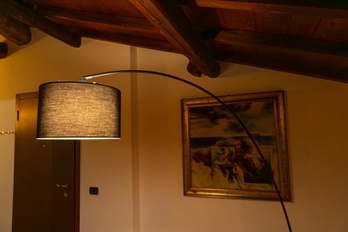 une lampe accrochée dans une pièce avec un tableau dans l'établissement Suite Carlo - Modena, à Casinalbo