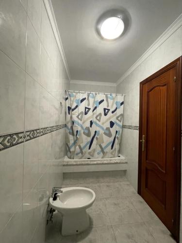 a bathroom with a toilet and a shower curtain at Apartamento Castiñeira in Fisterra