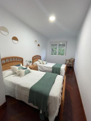 a bedroom with two beds and a window at Apartamento Castiñeira in Fisterra